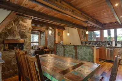 a dining room with a wooden table and a kitchen at Hoeck Hacienda By Hauserman Rentals in Tahoe City