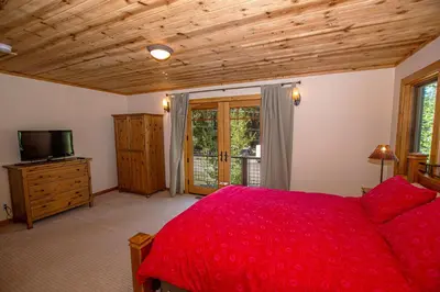 a bedroom with a red bed and a television at Bonanza By Hauserman Rentals in Tahoe City
