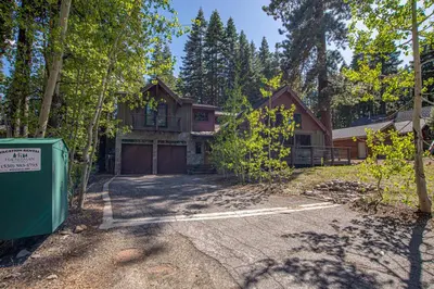 a house with a garage in the woods at Bonanza By Hauserman Rentals in Tahoe City