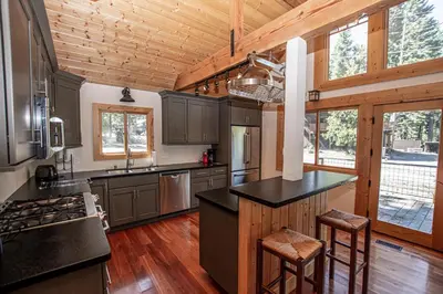 a kitchen with black countertops and wooden ceilings at Bonanza By Hauserman Rentals in Tahoe City
