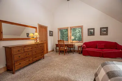 a bedroom with a red couch and a table at Celtic Lodge By Hauserman Rentals in Homewood