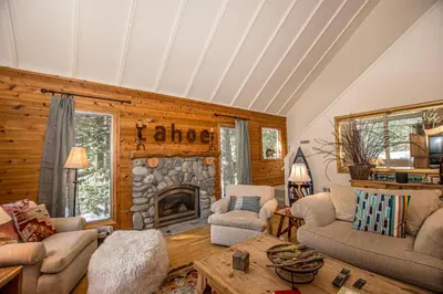 a living room with a stone fireplace in a cabin at Carnelian Bay Hideaway By Hauserman Rentals in Carnelian Bay