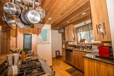 a kitchen with wooden cabinets and a stove top oven at Carnelian Bay Hideaway By Hauserman Rentals in Carnelian Bay