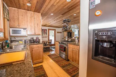 a kitchen with wooden cabinets and a stove top oven at Carnelian Bay Hideaway By Hauserman Rentals in Carnelian Bay