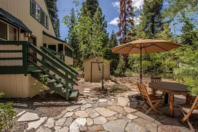 a patio with an umbrella and a table and chairs at Carnelian Bay Hideaway By Hauserman Rentals in Carnelian Bay