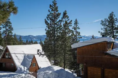 a house with snow on the roof and trees at Catalpa Vista By Hauserman Rentals in Tahoe Vista