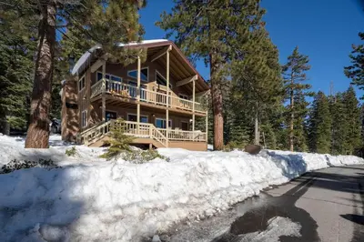 a log home in the woods in the snow at Catalpa Vista By Hauserman Rentals in Tahoe Vista
