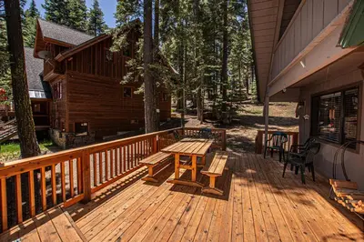 a wooden deck with a table and benches on a cabin at Das Berghaus By Hauserman Rentals in Tahoe City