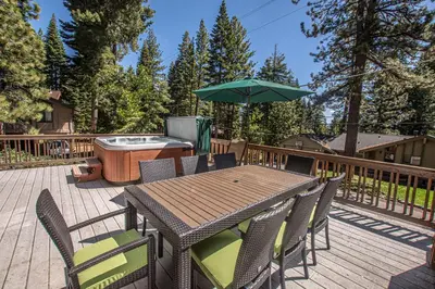 a deck with a table and chairs and a hot tub at Edelweiss Escape By Hauserman Rentals in Tahoe City