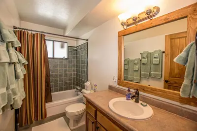 a bathroom with a sink and a toilet and a mirror at Edelweiss Escape By Hauserman Rentals in Tahoe City