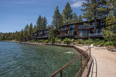 a row of apartment buildings next to a body of water at Star Harbor # 27 By Hauserman Rentals in Tahoe City