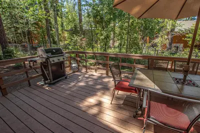 a grill on a deck with a table and chairs at Grainger By Hauserman Rentals in Tahoe City