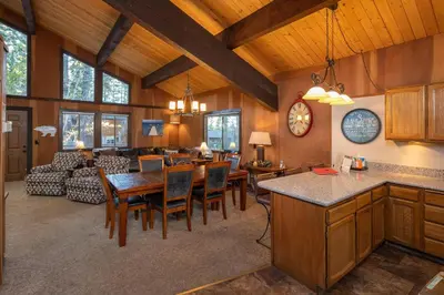 a kitchen and living room with a table and chairs at Grainger By Hauserman Rentals in Tahoe City