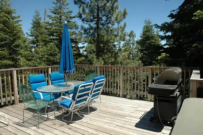 a patio with a table with chairs and an umbrella and a grill at Garret's Place By Hauserman Rentals in Tahoe City
