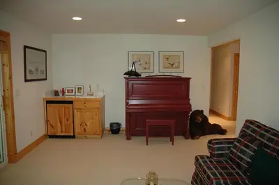 a living room with a piano and a dog laying on the floor at Going By Hauserman Rentals in Homewood