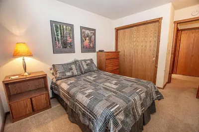 a bedroom with a bed and a lamp and a door at Vance By Hauserman Rentals in Tahoe City