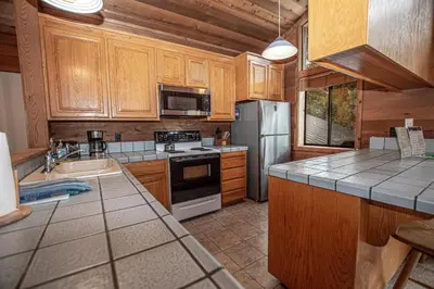 a kitchen with wooden cabinets and stainless steel appliances at Vance By Hauserman Rentals in Tahoe City