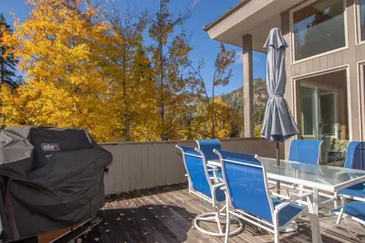 a patio with a table and chairs and an umbrella at Snow Crest By Hauserman Rentals in Alpine Meadows