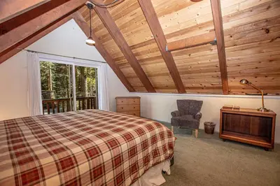 a bedroom with a bed and a chair and a window at Hillhouse By Hauserman Rentals in Homewood