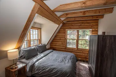 a bedroom with a bed in a room with wooden walls at Little Bear Cabin By Hauserman Rentals in Tahoe Vista