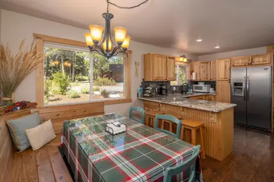 a kitchen with a table and a refrigerator at Cedarwood Serenity By Hauserman Rentals in Tahoe City