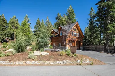 a log house in the woods with a driveway at Cedarwood Serenity By Hauserman Rentals in Tahoe City