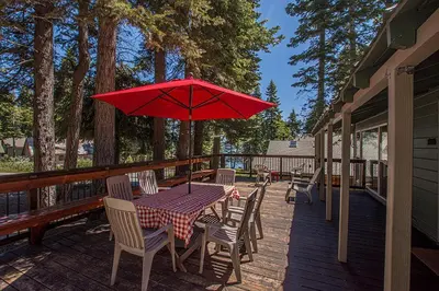 a table and chairs with a red umbrella on a deck at Holland By Hauserman Rentals in Homewood