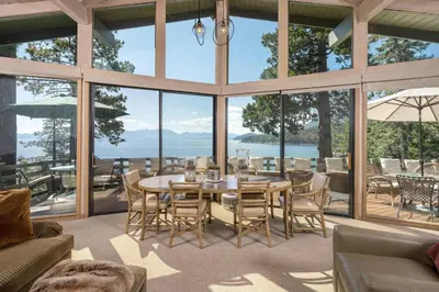 a dining room with a table and chairs and windows at McCown Lakefront By Hauserman Rentals in Tahoma