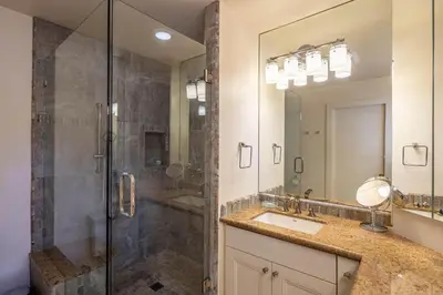a bathroom with a shower and a sink and a mirror at McCown Lakefront By Hauserman Rentals in Tahoma