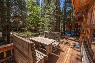 a wooden deck with a table and benches on a cabin at Plesums By Hauserman Rentals