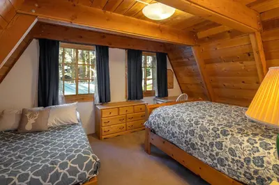 a bedroom with a bed in a log cabin at Poplar Place By Hauserman Rentals in Homewood