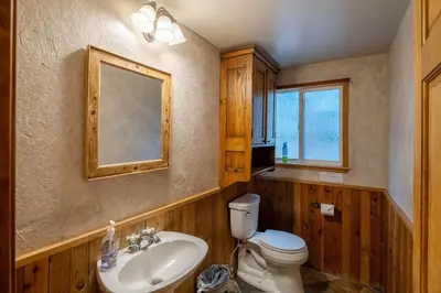 a bathroom with a sink and a toilet and a mirror at Molly's Treehouse By Hauserman Rentals in Carnelian Bay