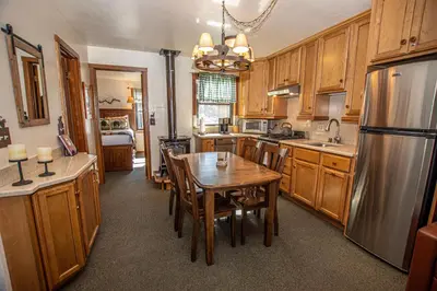 a kitchen with a wooden table and a refrigerator at Franciscan Lakeside # 29 By Hauserman Rentals in Tahoe Vista