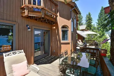 a patio with a glass table and a balcony at Rygh Lakefront By Hauserman Rentals in Carnelian Bay