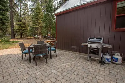 a patio with a grill and a table and chairs at O'Brien's Den By Hauserman Rentals in Tahoma