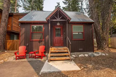 a small cabin with two chairs and a red door at O'Brien's Den By Hauserman Rentals in Tahoma