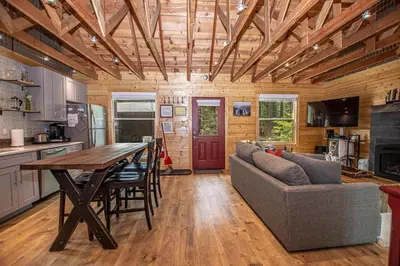 a kitchen and living room with a table and a couch at O'Brien's Den By Hauserman Rentals in Tahoma