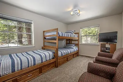 a bedroom with two bunk beds and a flat screen tv at Shean By Hauserman Rentals in Tahoe City