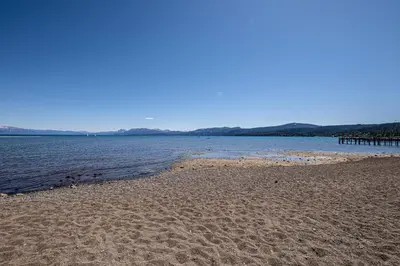 a sandy beach next to a body of water at St Francis #53 By Hauserman Rentals in Tahoe City