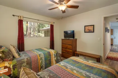 a bedroom with two beds and a flat screen tv at Squirrels Nest By Hauserman Rentals in Carnelian Bay