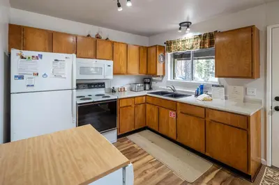 a kitchen with wooden cabinets and a white refrigerator at Squirrels Nest By Hauserman Rentals in Carnelian Bay