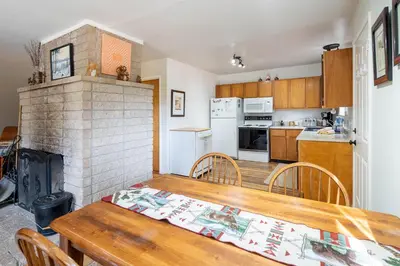 a kitchen and dining room with a table and a fireplace at Squirrels Nest By Hauserman Rentals in Carnelian Bay