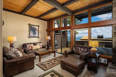 a living room with leather furniture and large windows at Star Harbor # 4 By Hauserman Rentals in Tahoe City