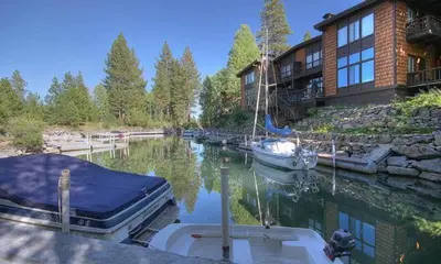a boat is docked in a marina in front of a house at Star Harbor # 15 By Hauserman Rentals in Tahoe City
