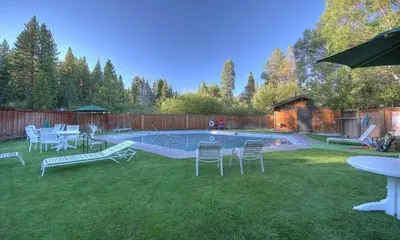 a backyard with a pool with chairs and a table at Star Harbor # 8 By Hauserman Rentals in Tahoe City