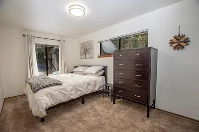 a bedroom with a bed and a dresser and a window at Tahoma Treasures Emerald Cabin Hauserman Rentals in Tahoma