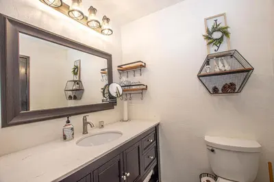 a bathroom with a sink and a mirror and a toilet at Tahoma Treasures Emerald Cabin Hauserman Rentals in Tahoma