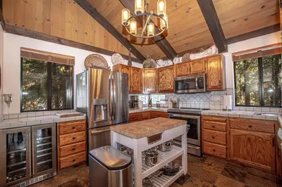 a kitchen with wooden cabinets and stainless steel appliances at Thunder Lodge By Hauserman Rentals in Homewood