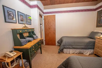 a bedroom with two beds and a dresser with a desk at Willow By Hauserman Rentals in Tahoe City