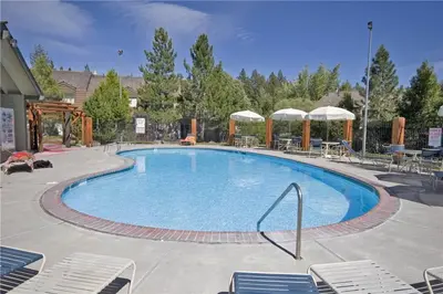 a large swimming pool with chairs and umbrellas at Lake Forest Glen # 114 By Hauserman Rentals in Tahoe City